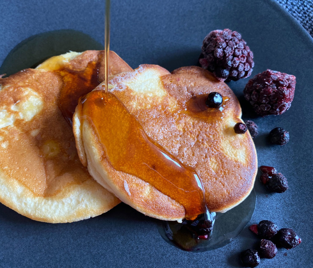 Leckere Pancakes mit Ahornsirup und Beeren